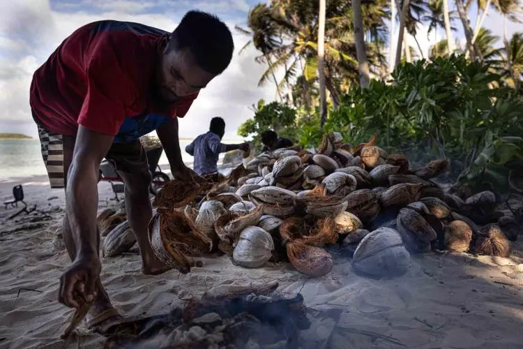 Locals gather and burn coconut shells for the building cement, Ebadon. Photo by Lorenzo Moscia.